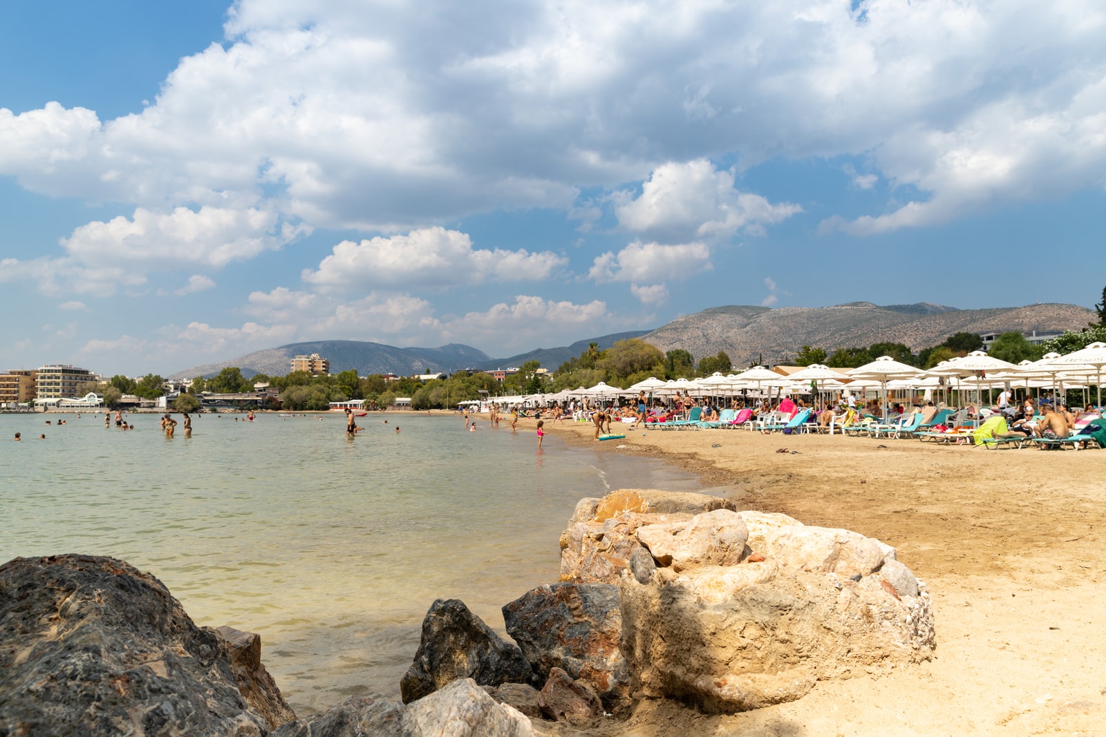 An aerial view of a crowded beach club with rows of umbrellas on a sunny day.