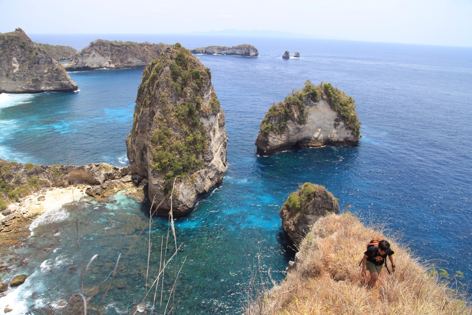 Limestone sea stacks rise from the turquoise water at Atuh Beach in Nusa Penida.