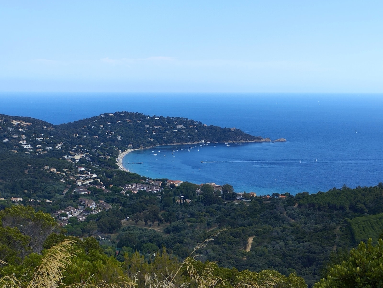 An aerial view shows the sweeping crescent shape of Cavalière Bay.