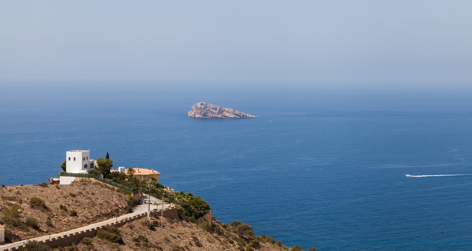 A view looking out toward the distinctive silhouette of Benidorm Island in the Mediterranean.