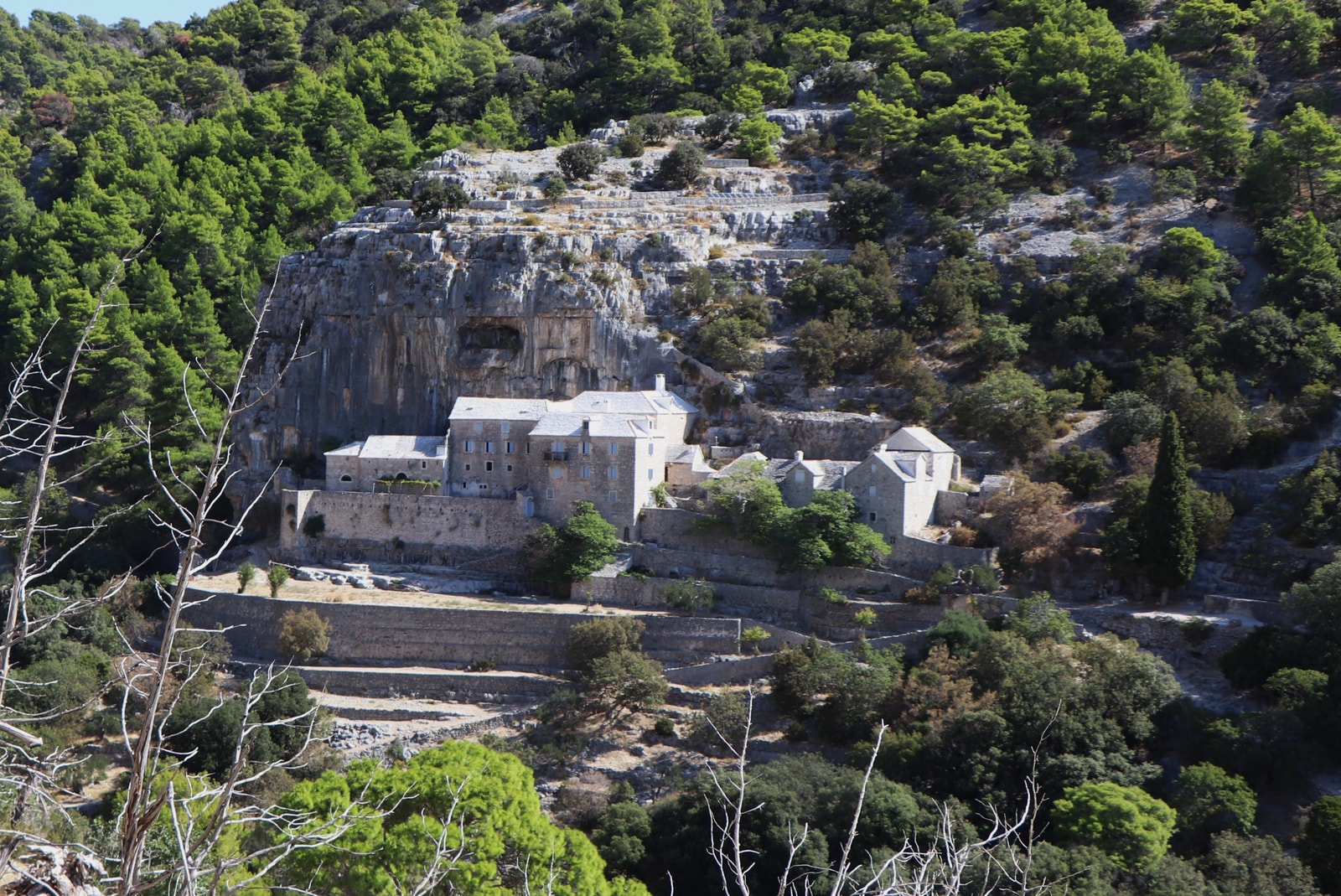 The Blaca Hermitage, a historic monastery, is built dramatically into the side of a sheer rock cliff in a remote canyon.