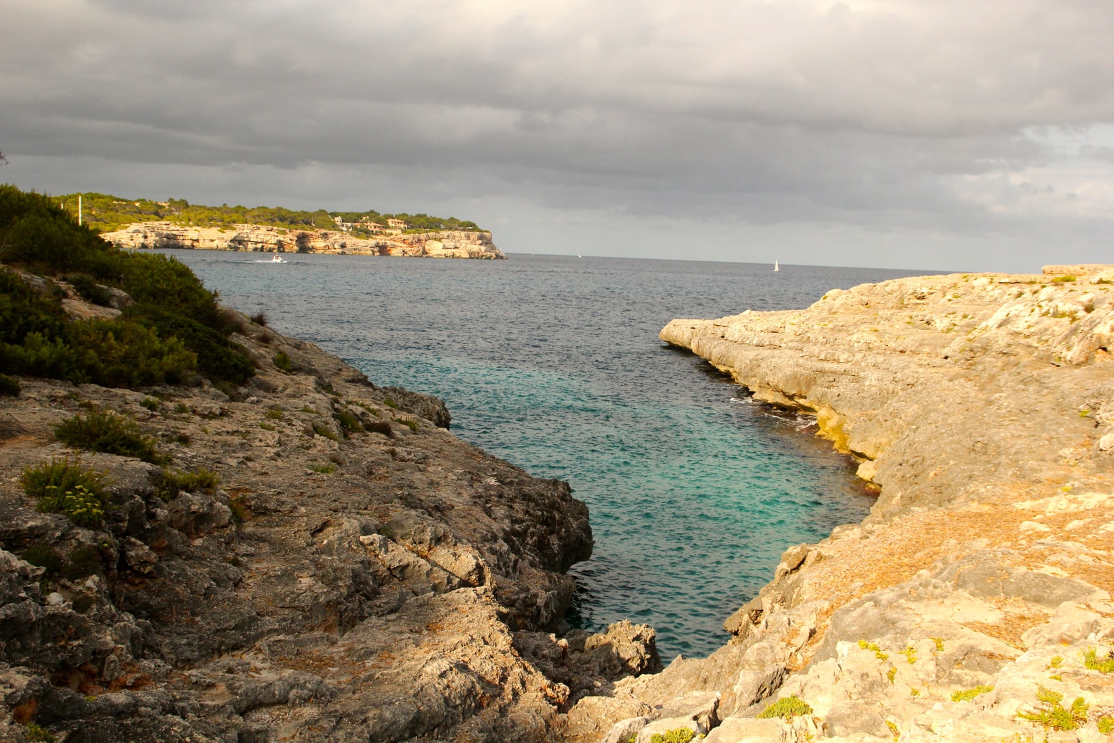 A rugged, undeveloped rocky inlet known as Caló d'en Perdiu, with clear water and natural limestone cliffs.