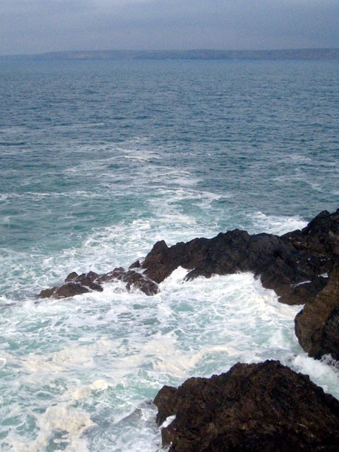 Waves crash over the jagged rocks of the Cribbar Reef below Towan Headland.