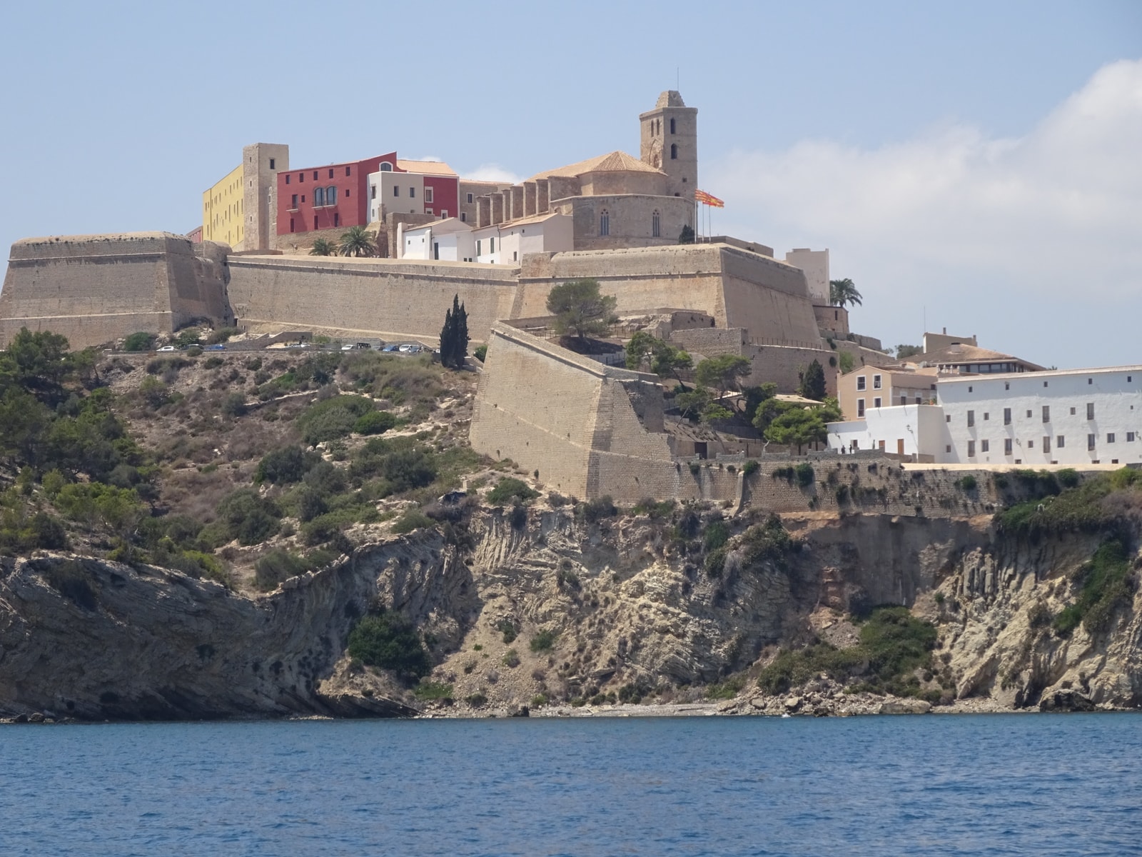 A scenic view of Dalt Vila, Ibiza's old town, from across the water, showing the fortified walls and cathedral.