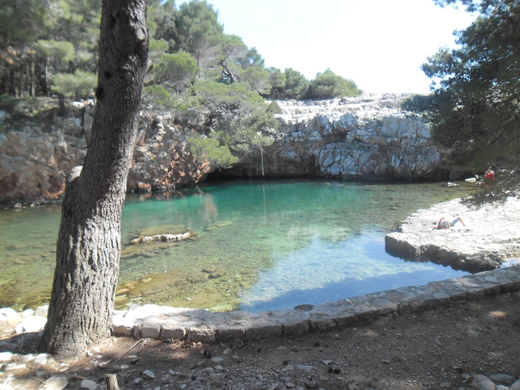 The calm, green-hued water of the Mrtvo More (Dead Sea), a small saltwater lake on Lokrum Island, is a popular swimming spot.