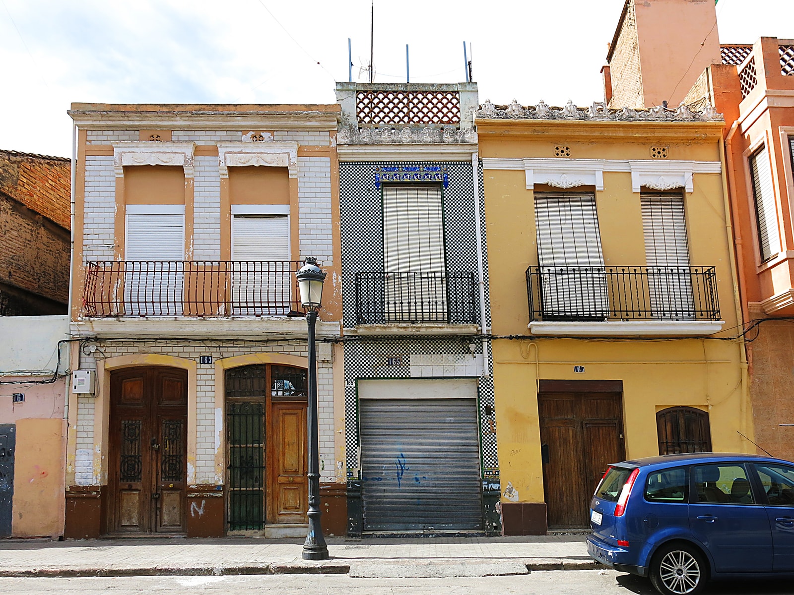 Traditional two-story homes in the El Cabañal neighborhood, featuring colorful facades with intricate glazed ceramic tiles (azulejos).