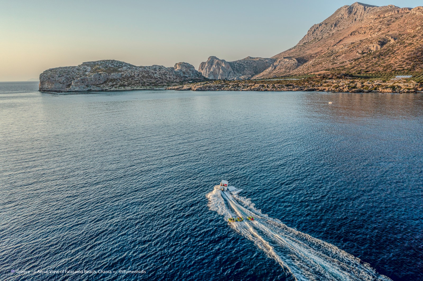 An aerial drone view showcases the vast expanse of golden sand and turquoise waters at Falassarna Beach.