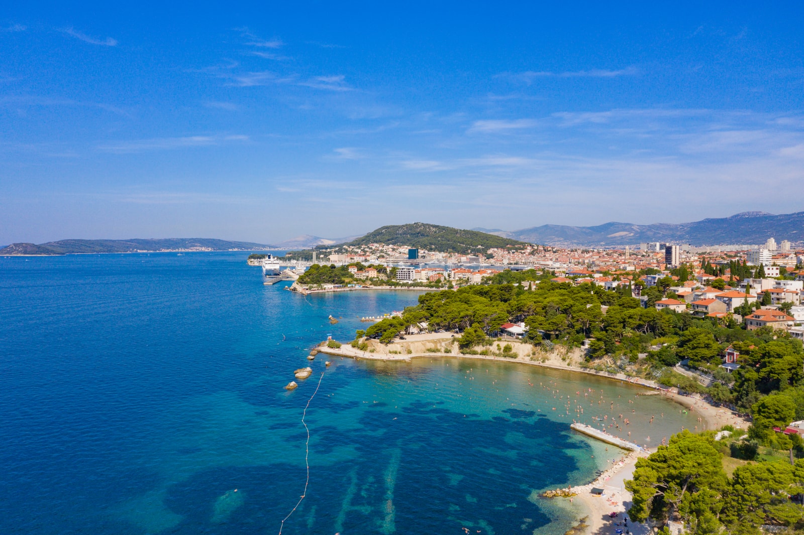 High-altitude aerial viewpoint of the sandy, protected cove at Firule Beach in Split.