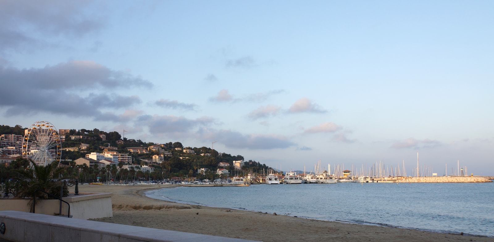 The Grande Plage of Le Lavandou in the morning, with a Ferris wheel in the background.