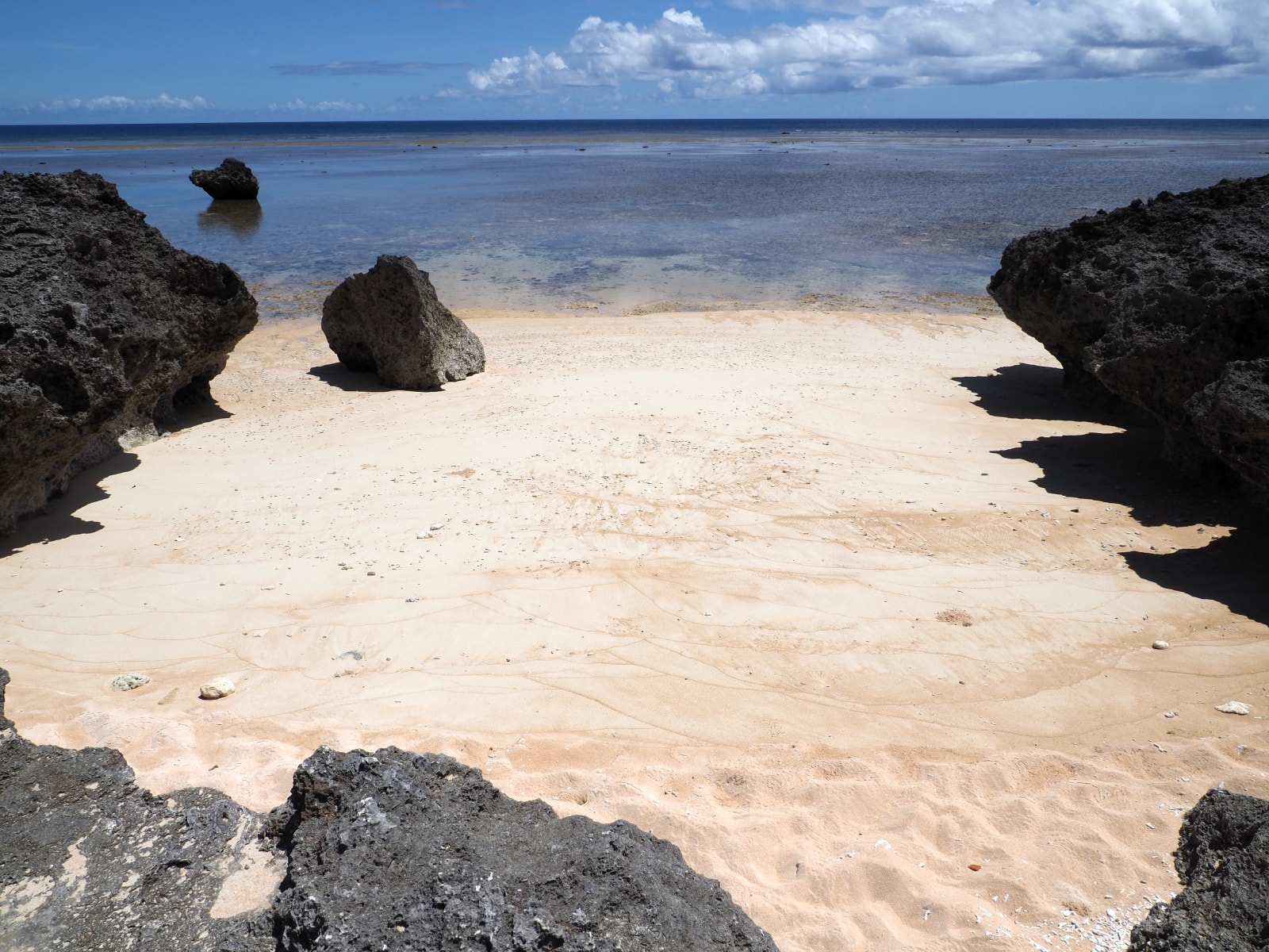 A serene cove with turquoise water surrounded by lush green vegetation.