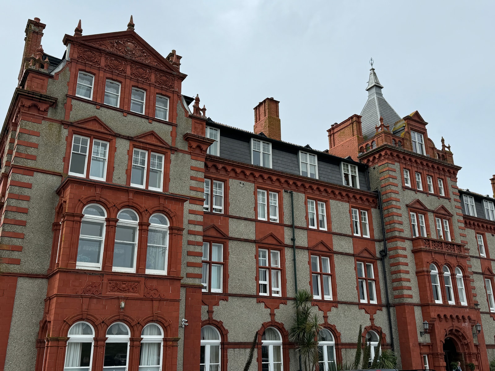 A detailed view of the grand Victorian red-brick facade of The Headland Hotel.