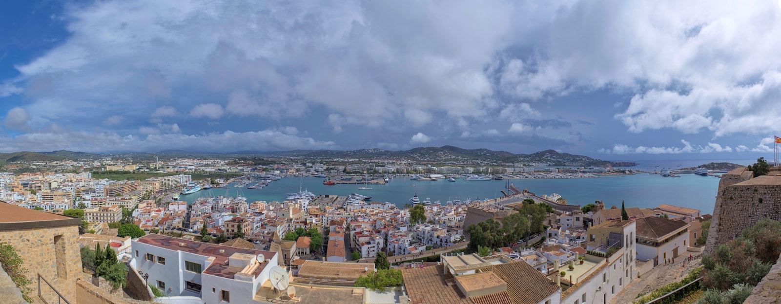 A wide panoramic shot of Ibiza Town and its harbor, seen from an elevated viewpoint.