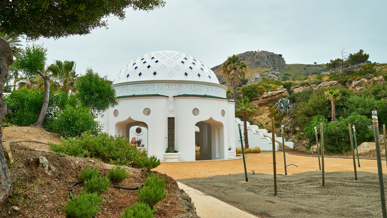 The restored domed pavilion of Kallithea Springs, with landscaped gardens and the sea in the background.