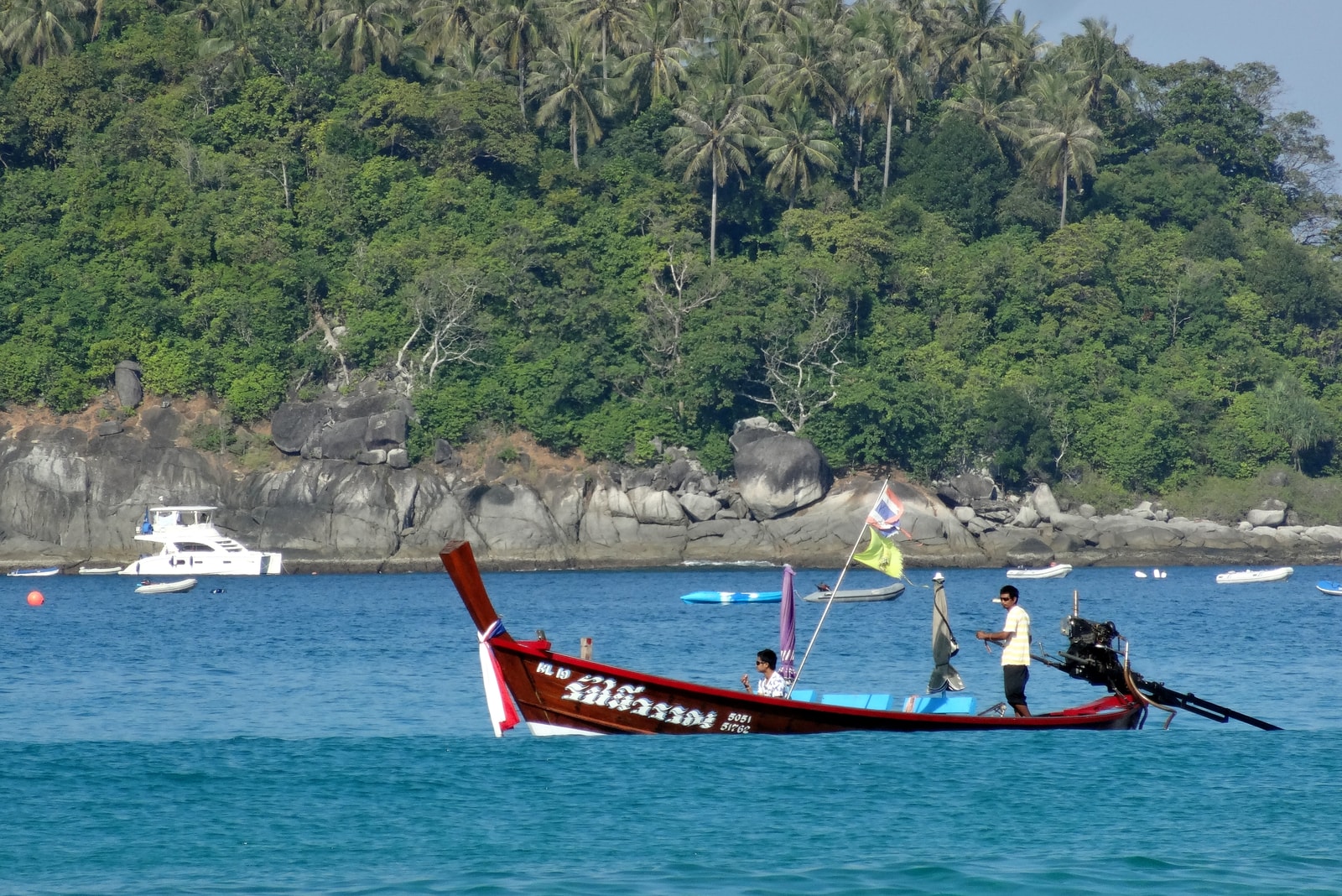 A brightly colored longtail boat rests on the sands of Kata Beach, ready for its next journey.