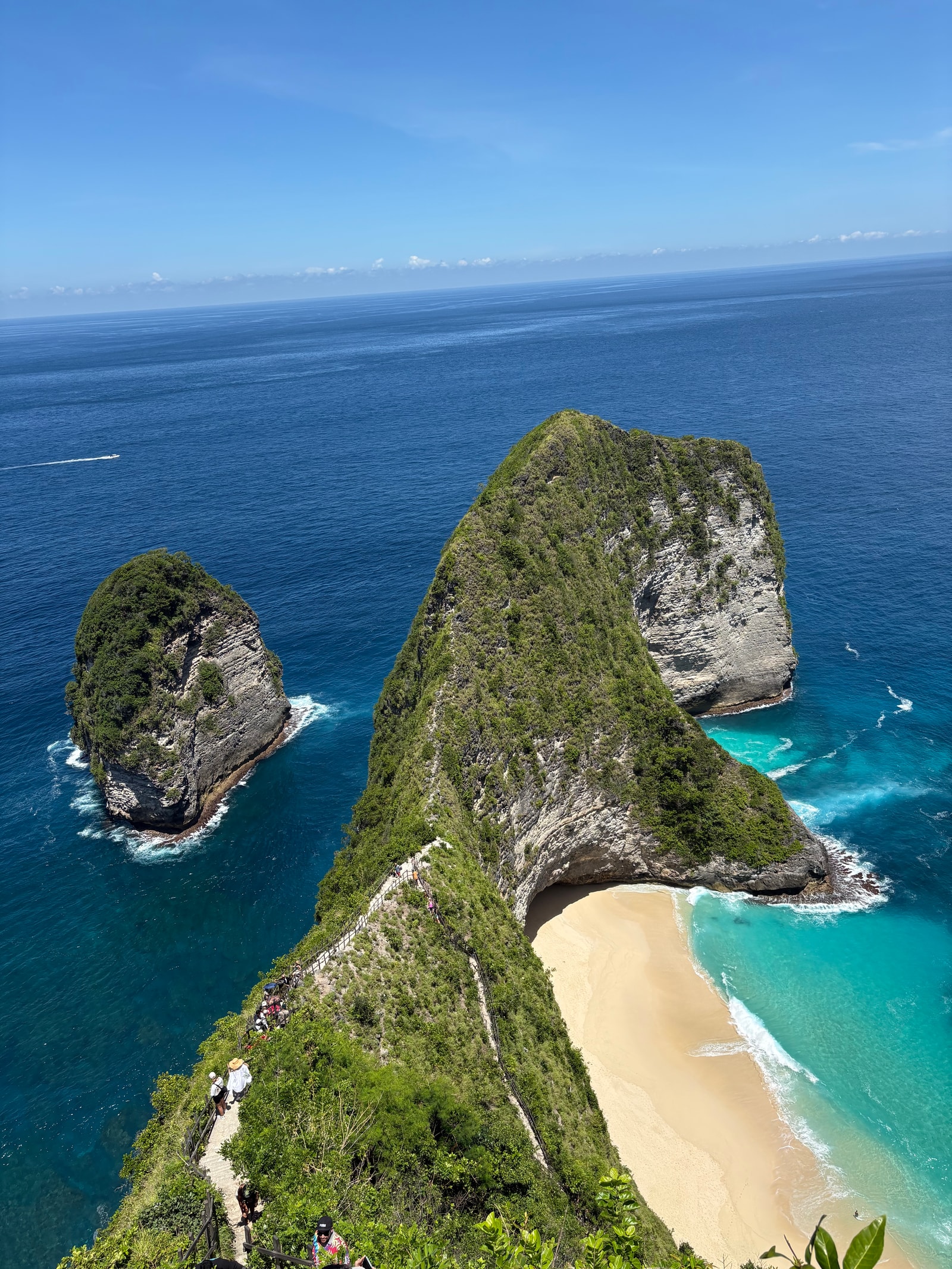 A vertical shot emphasizing the steep drop from the ridge down to the tiny beach and rocks below.