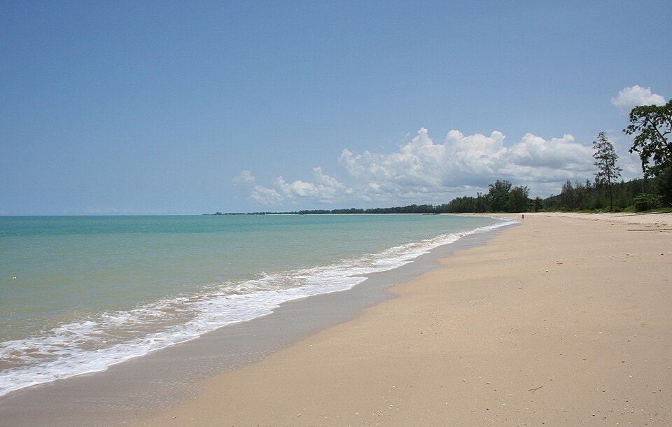 A wide, curving shoreline with turquoise water and clean, spacious sand at Khao Lak.