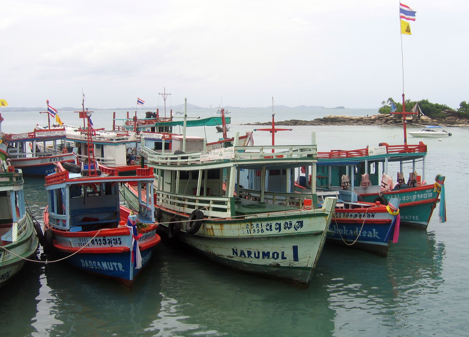 Colorful passenger and fishing boats moored in the harbor at Koh Samet.