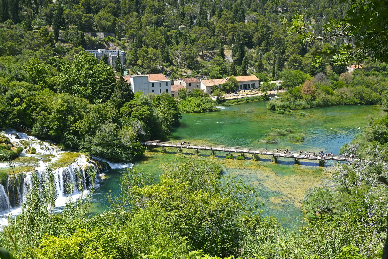 The majestic, tiered Skradinski Buk waterfall in Krka National Park, with lush forests and wooden footbridges.