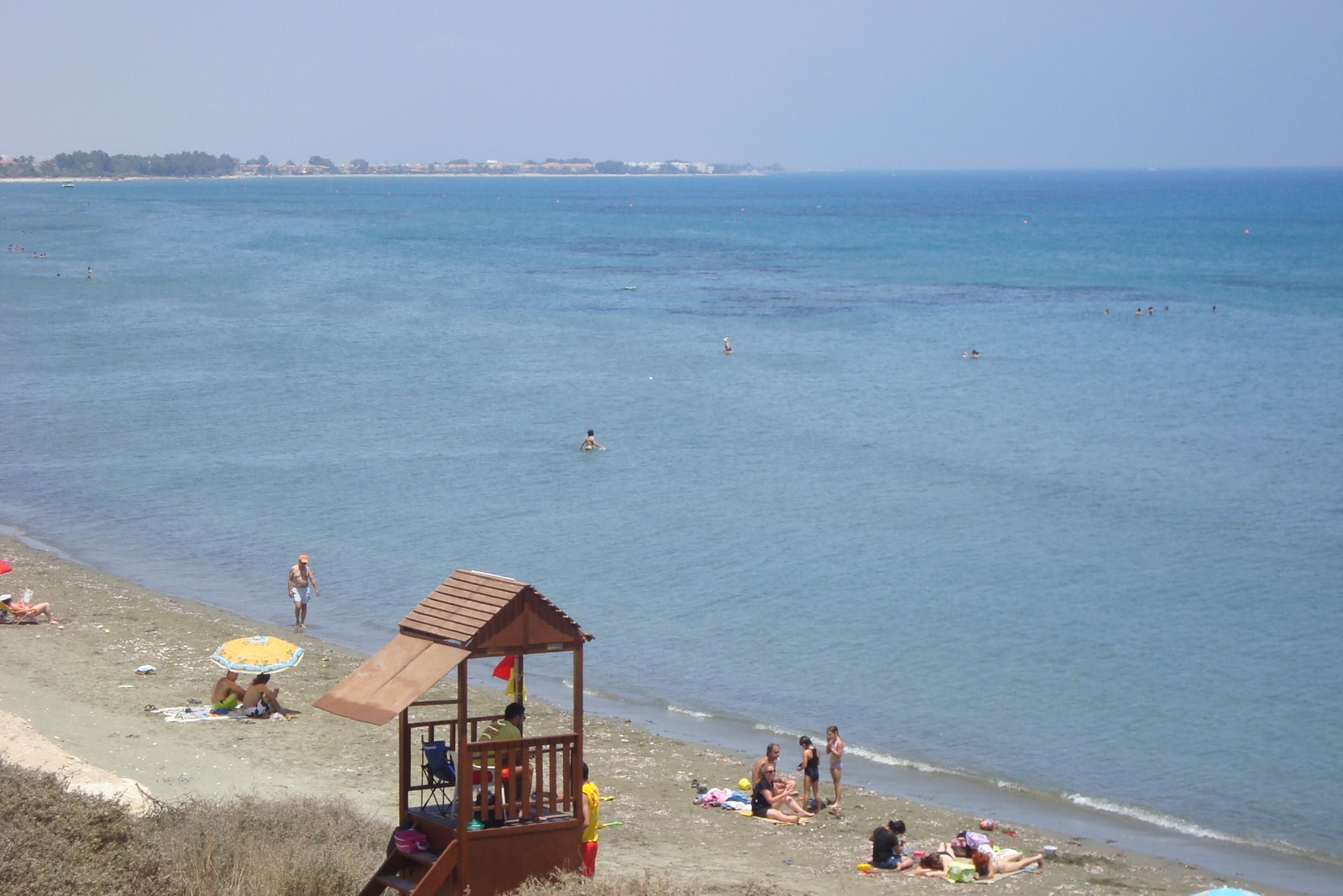 A lifeguard hut stands on Faros Beach with calm turquoise water in the background.
