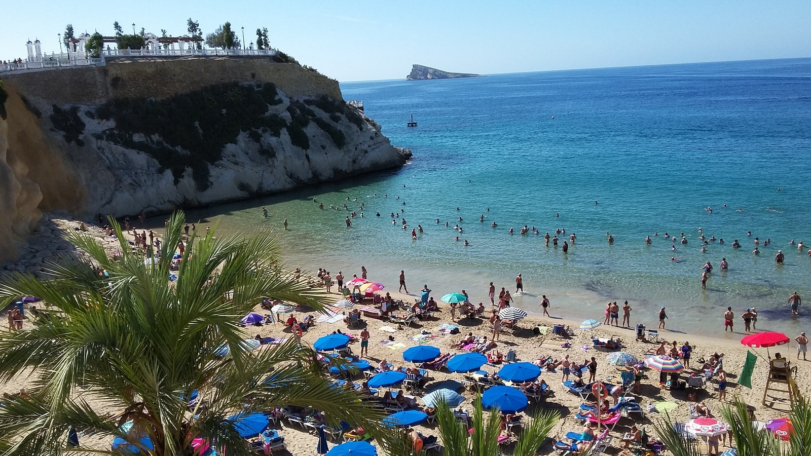 A view of the cozy Mal Pas Beach sheltered by the cliffs of Punta Canfali, with Benidorm Island on the horizon.