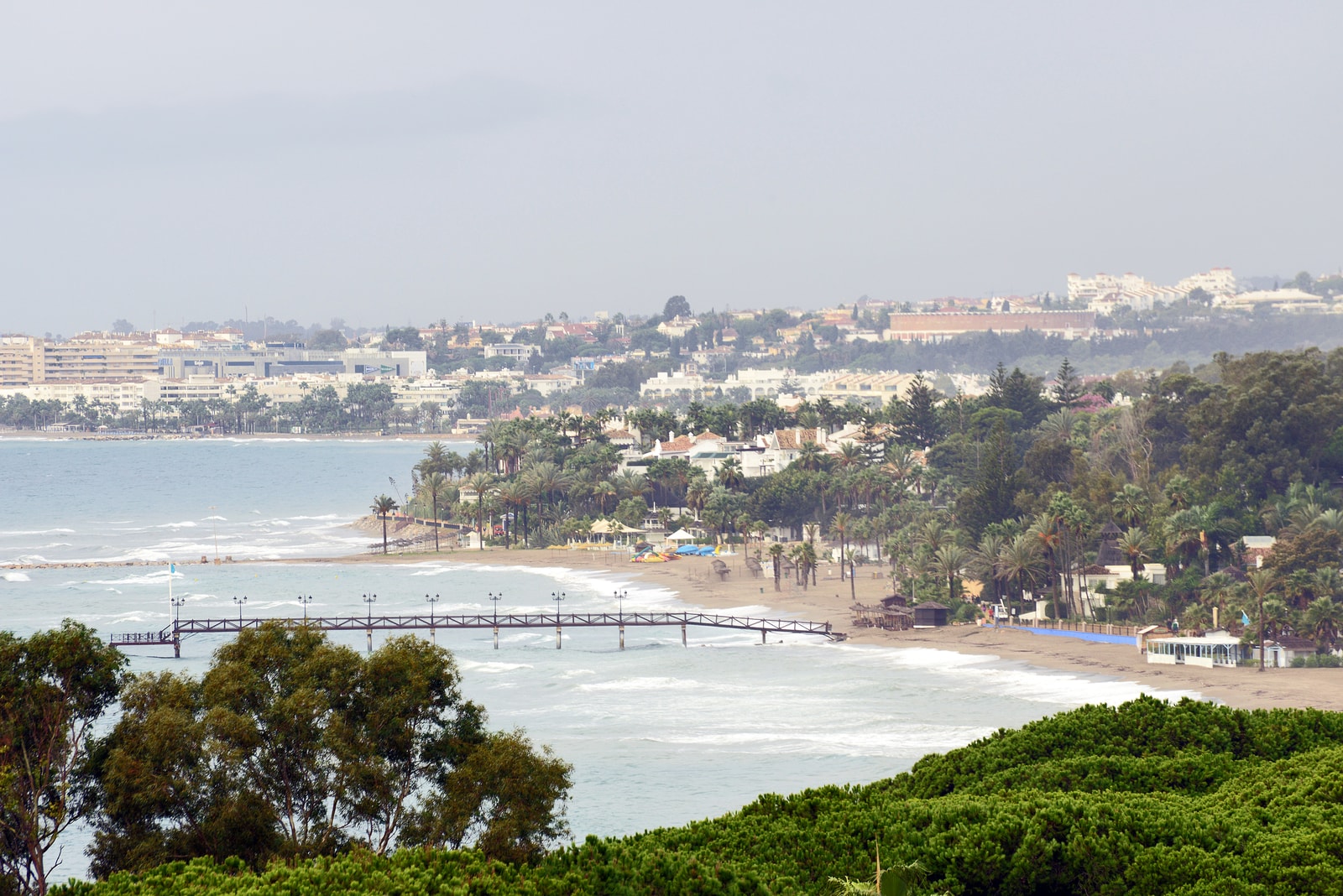 The historic wooden pier of the Marbella Club Hotel extending out into the calm Mediterranean Sea on the Golden Mile.