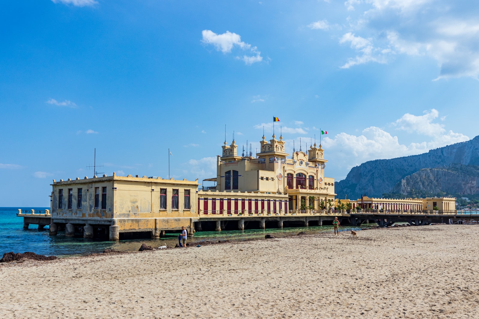 A view of the Antico Stabilimento Balneare from the side, showing its position over the water with Monte Pellegrino in the background.