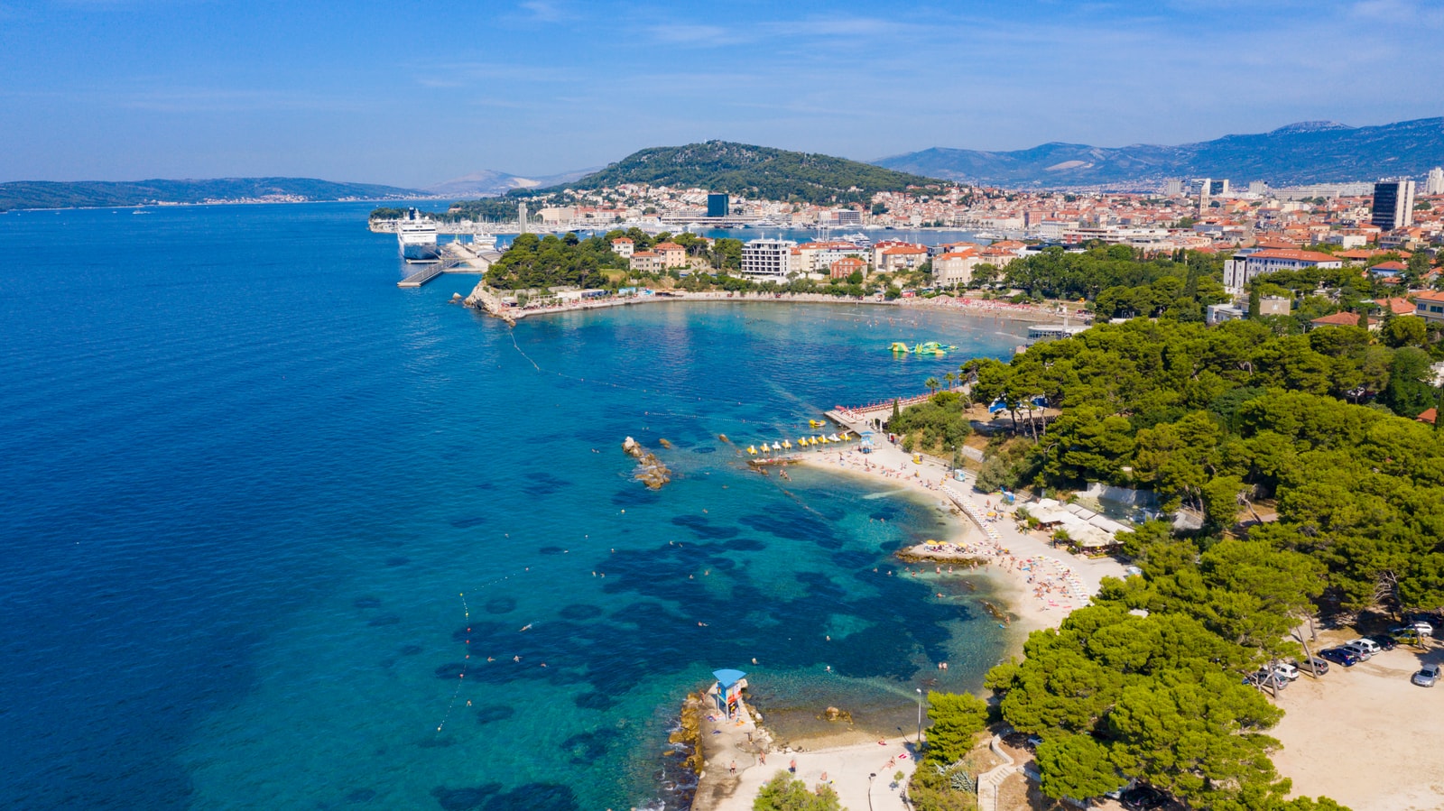 High-altitude aerial view showcasing Ovćice Beach in the foreground and Bačvice Beach immediately in the background.