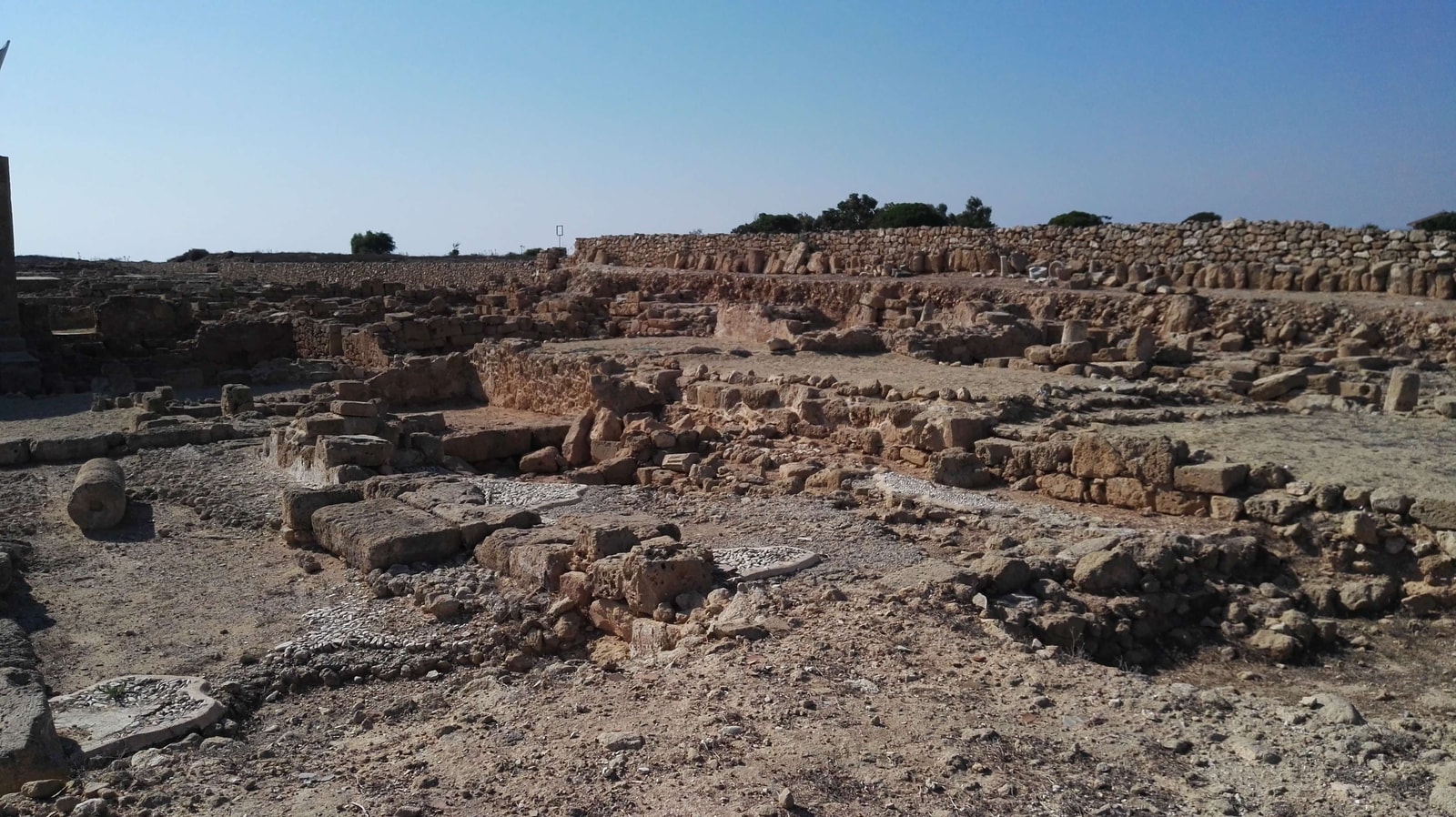 Sunlit excavated stone ruins at the House of Aion within the Paphos Archaeological Park.