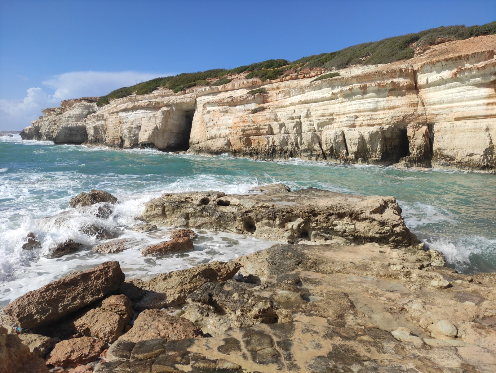 High-resolution view of stratified cliffs and a rocky shore at the Peyia Sea Caves.