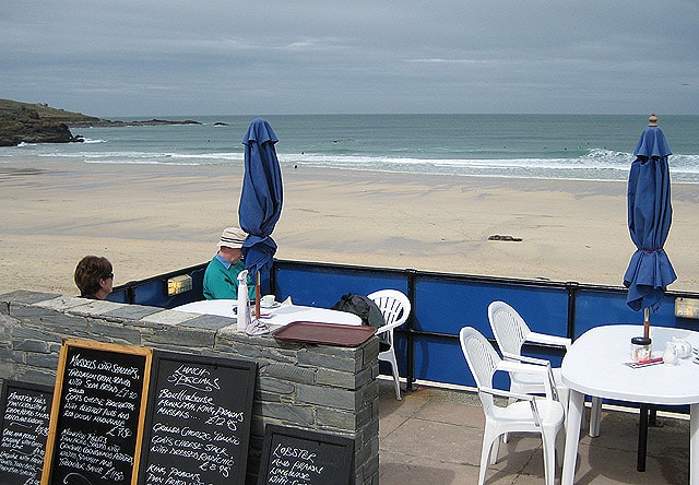 A beachfront cafe on Porthmeor beach displays a chalkboard menu advertising fresh, locally caught monkfish and mussels to diners on its patio overlooking the sea.