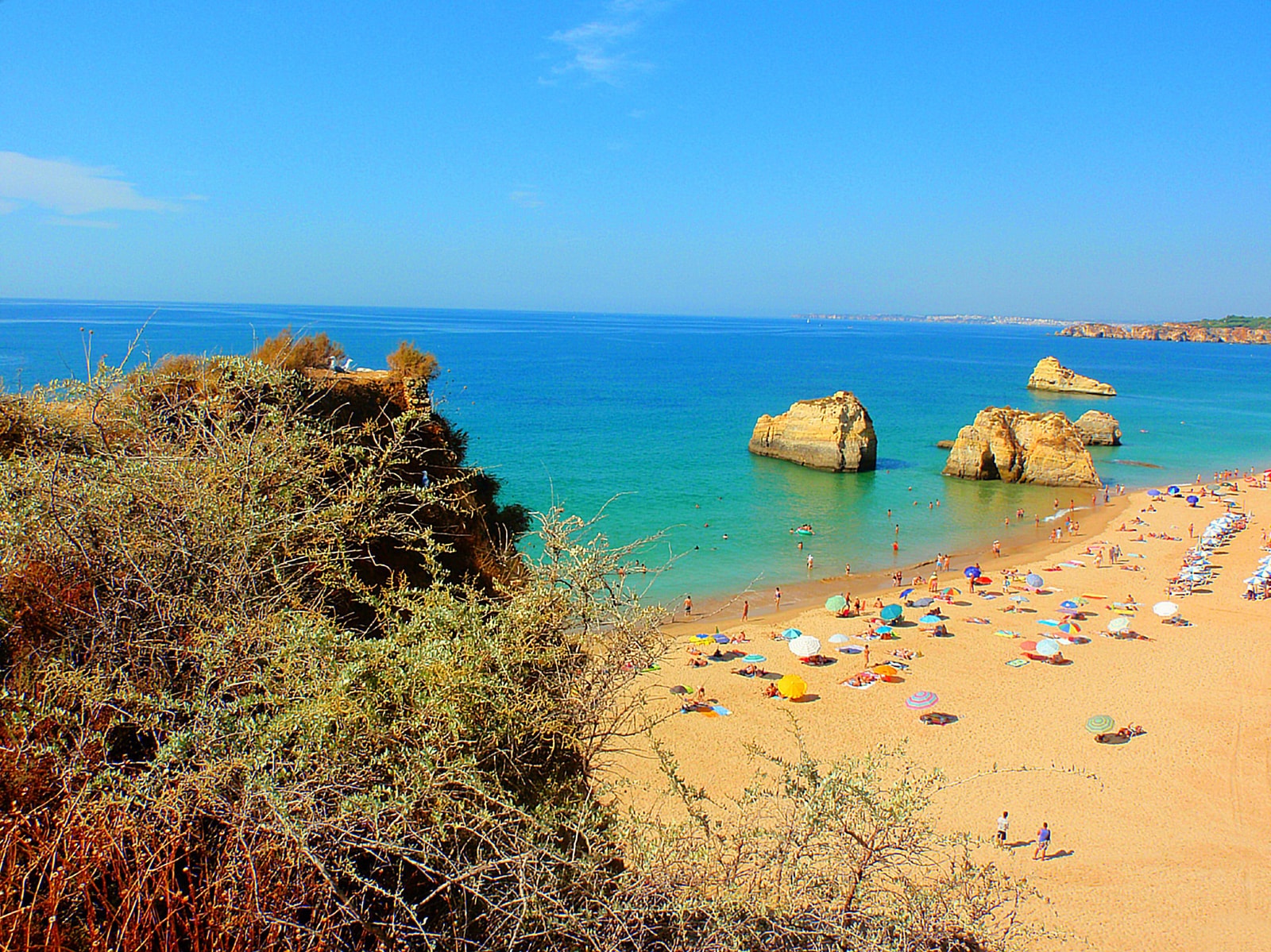 An elevated view looking down on the turquoise water and golden cliffs of Praia da Rocha.