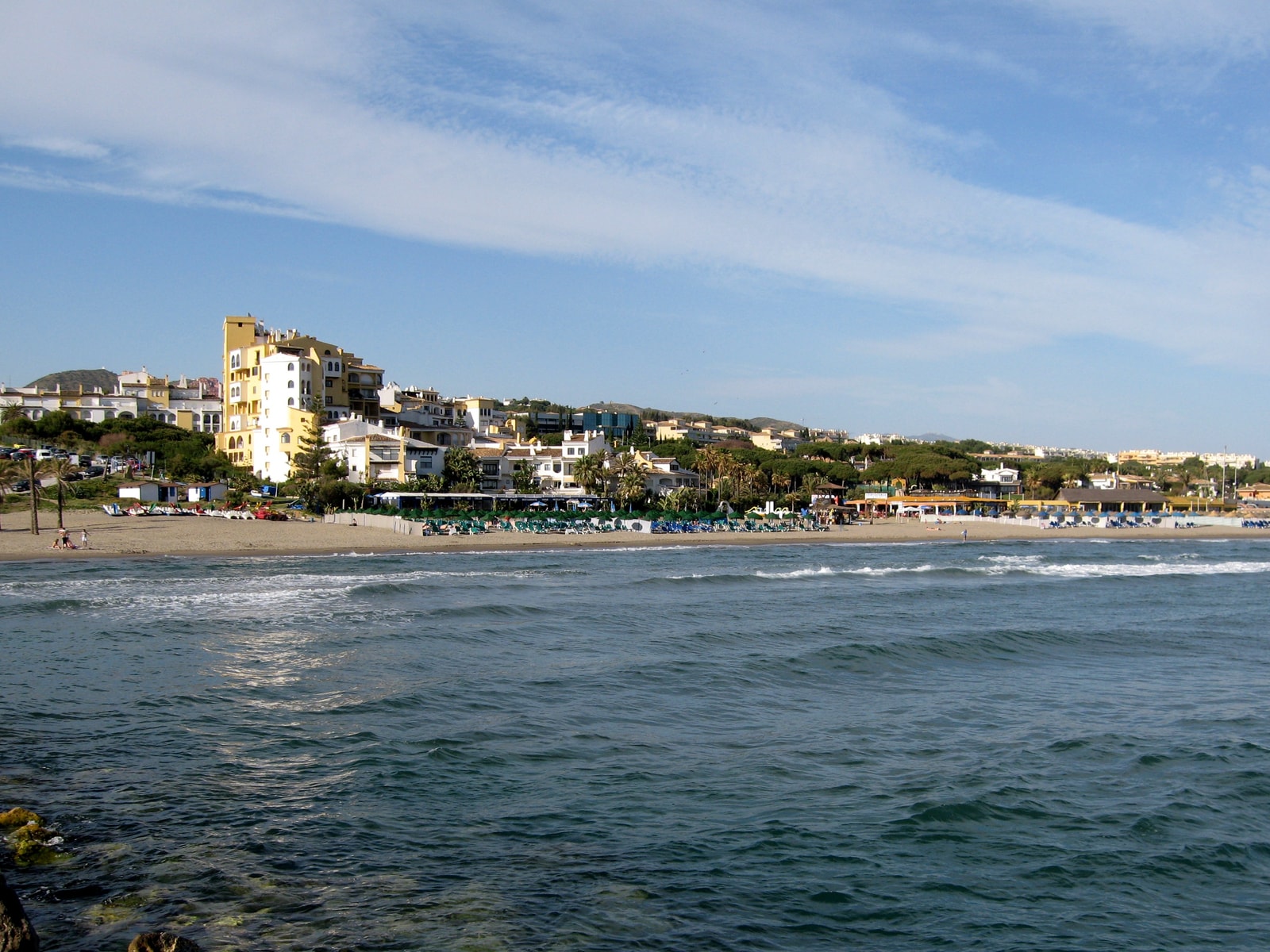 The traditional Mediterranean village architecture of Puerto Deportivo de Cabopino, with whitewashed buildings surrounding the tranquil marina.