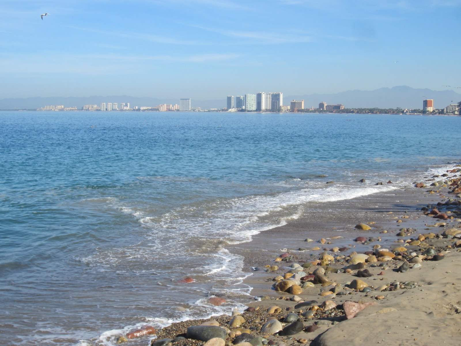 A view of Puerto Vallarta's Malecón waterfront promenade with the rocky shore and the bay.
