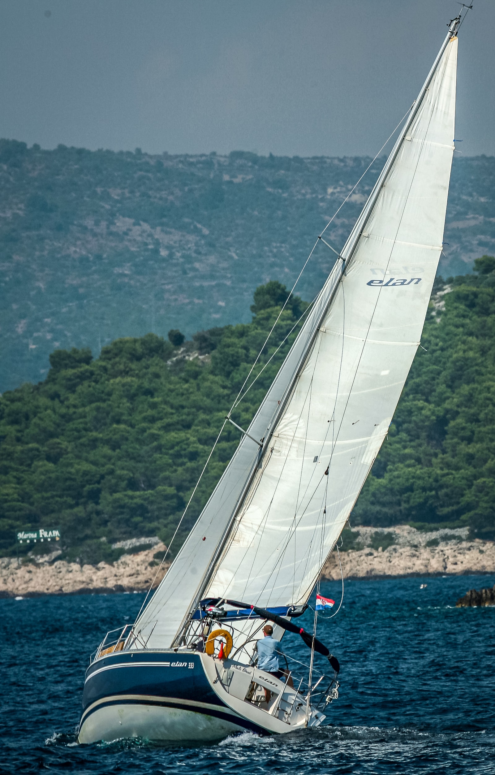 A sailboat with full sails cuts through the deep blue waters of the Adriatic Sea near Croatia.