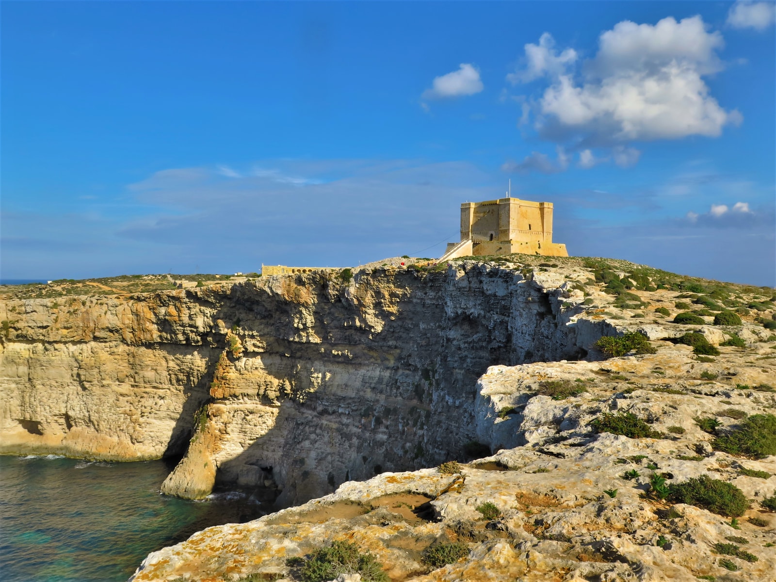 The formidable stone structure of St. Mary's Tower on a rocky promontory overlooking the sea.