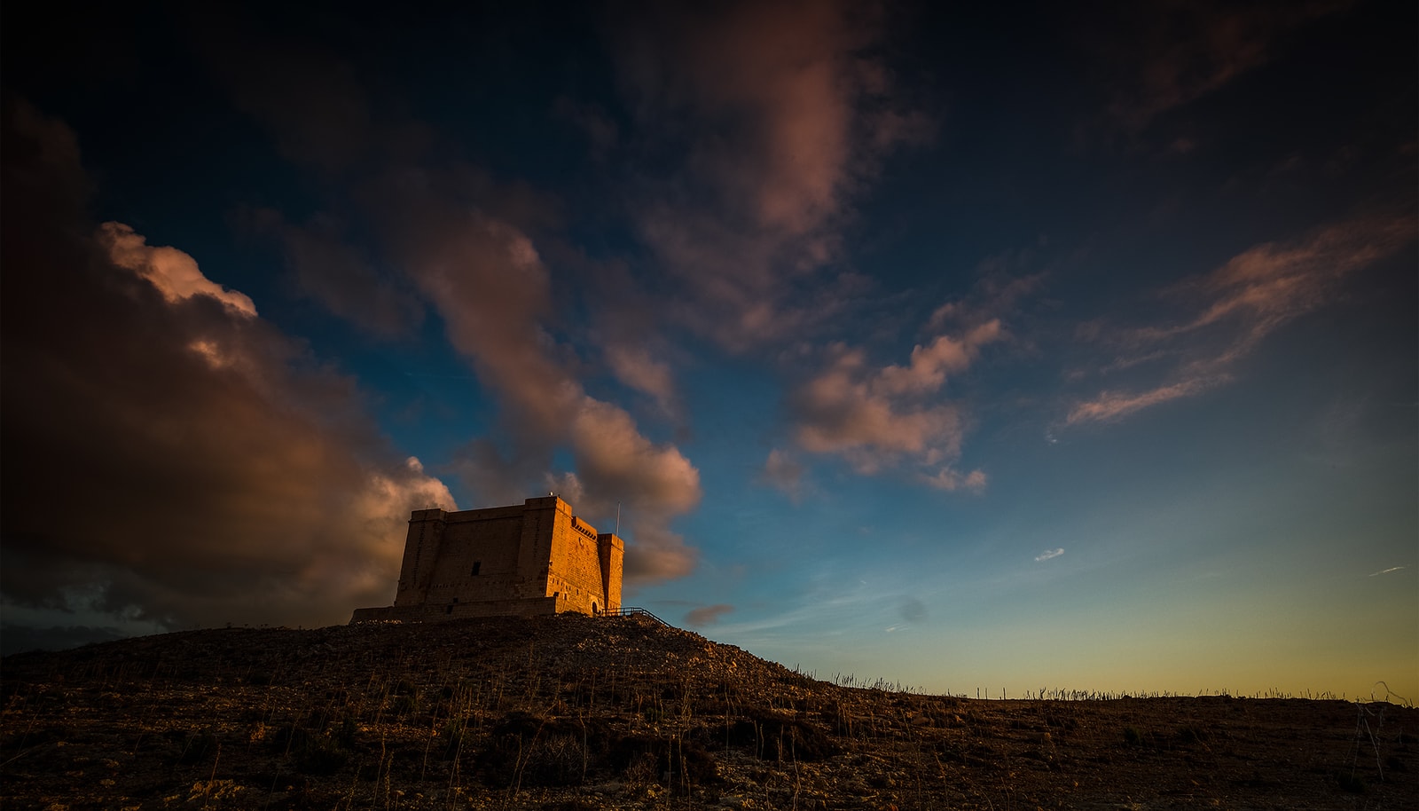 St. Mary's Tower silhouetted against a dramatic sunset sky.