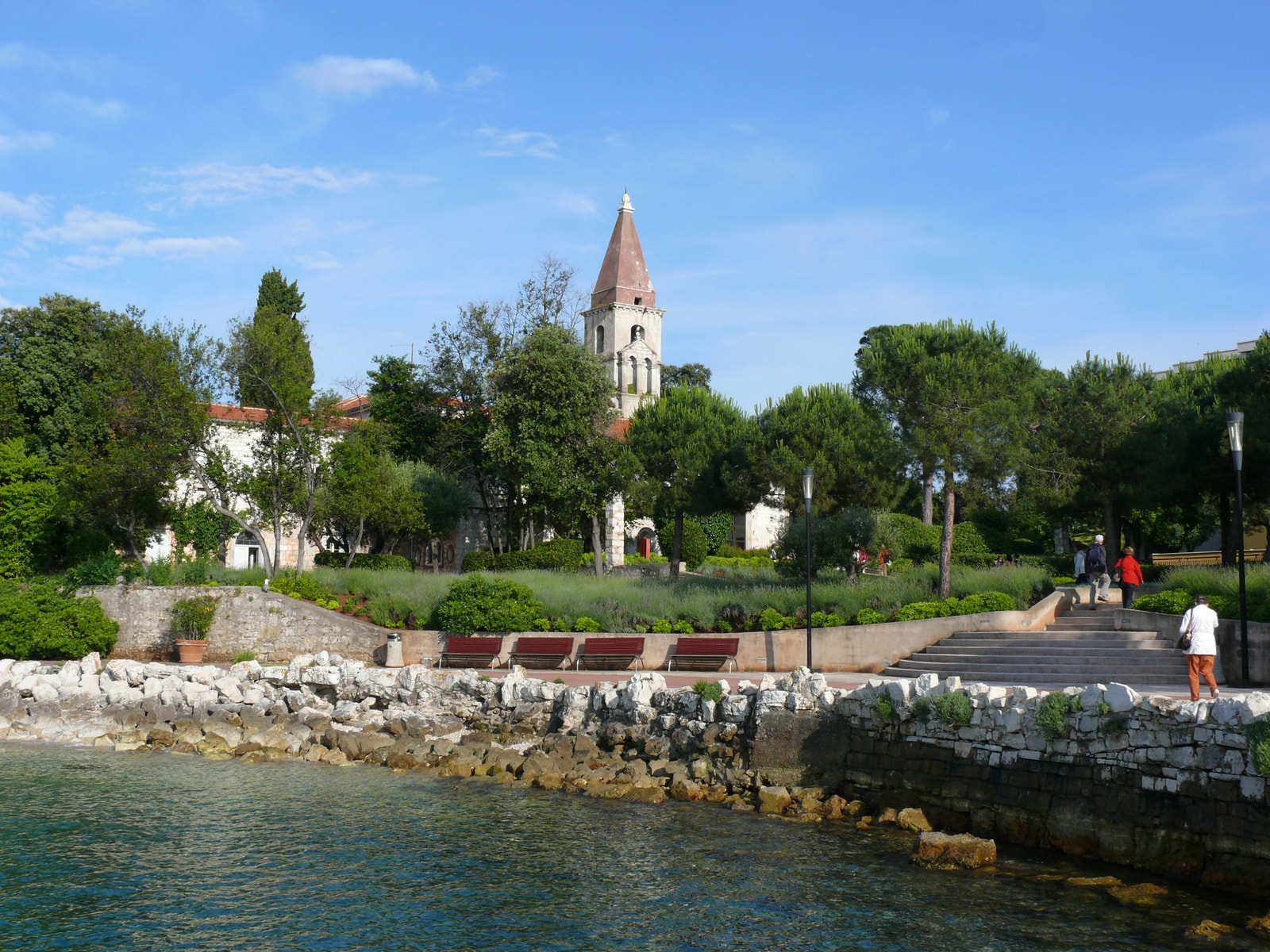 The historic Castle Huetterott on Sveti Andrija, with its red-steepled tower, manicured gardens, and stone sea walls.