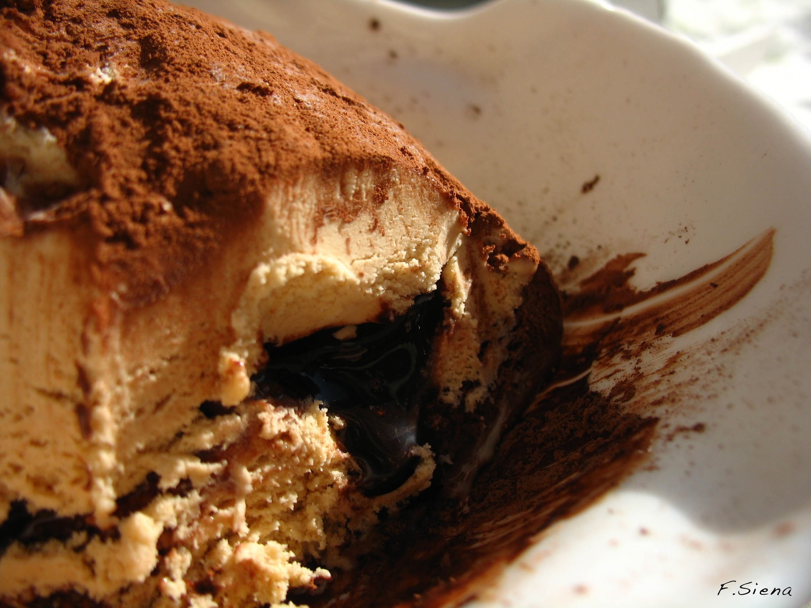 A close-up of a Tartufo di Pizzo gelato, cut open to reveal its molten liquid chocolate center.