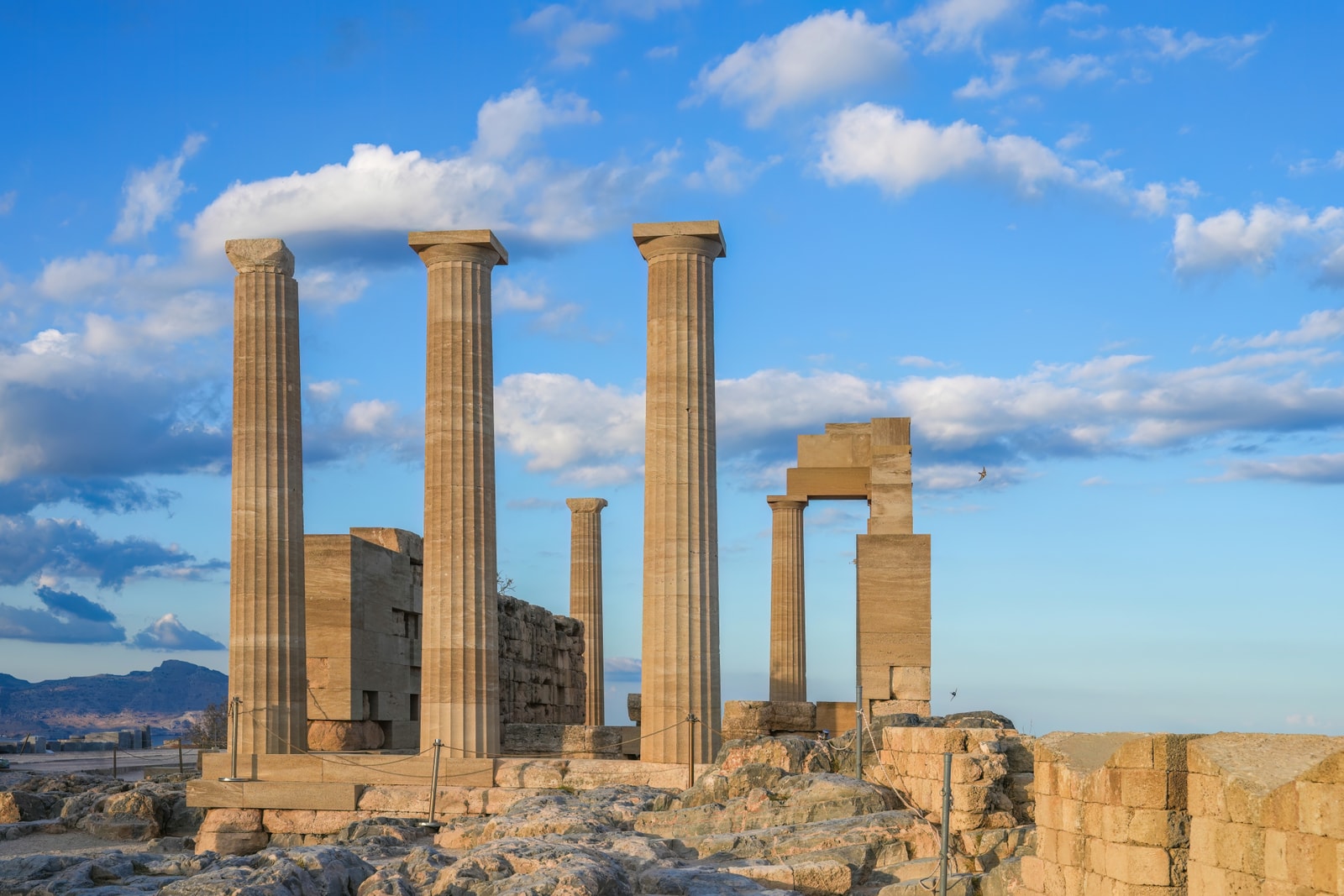 The ancient columns of the Temple of Athena Lindia stand against a dramatic sky at the Acropolis.