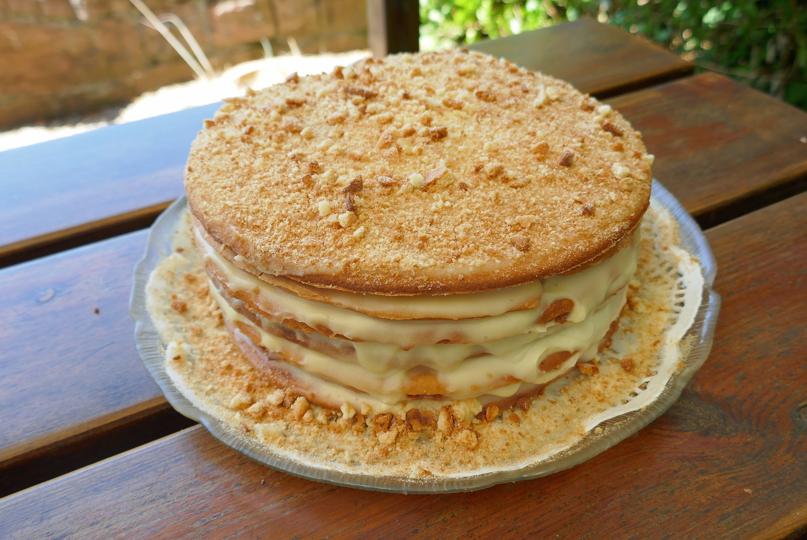 A slice of multi-layered Russian honey cake, known as Medovik, dusted with cake crumbs.