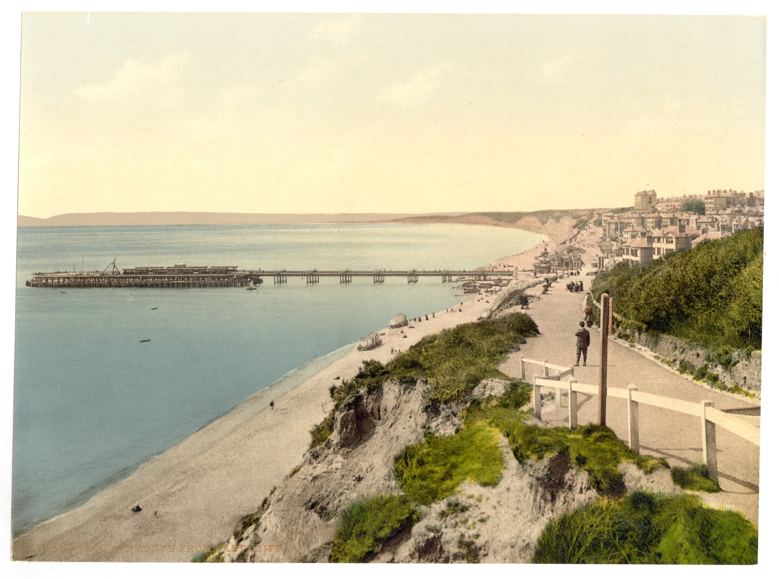 A vintage photochrom print from the late 19th century shows the Bournemouth coastline and pier from the East Cliff.