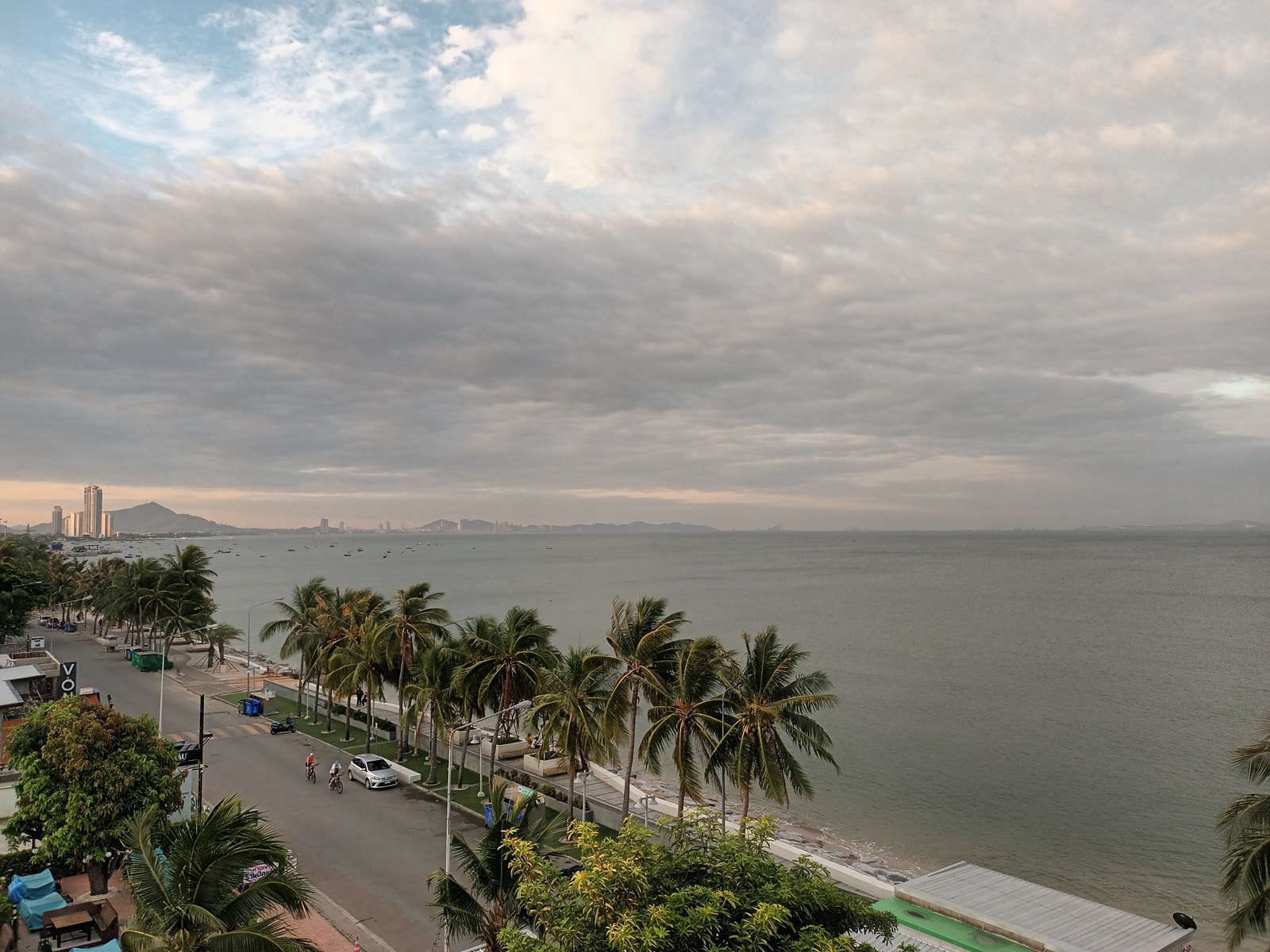 An elevated view of the road curving along Wonnapha Beach, showing the bay and coastal development.
